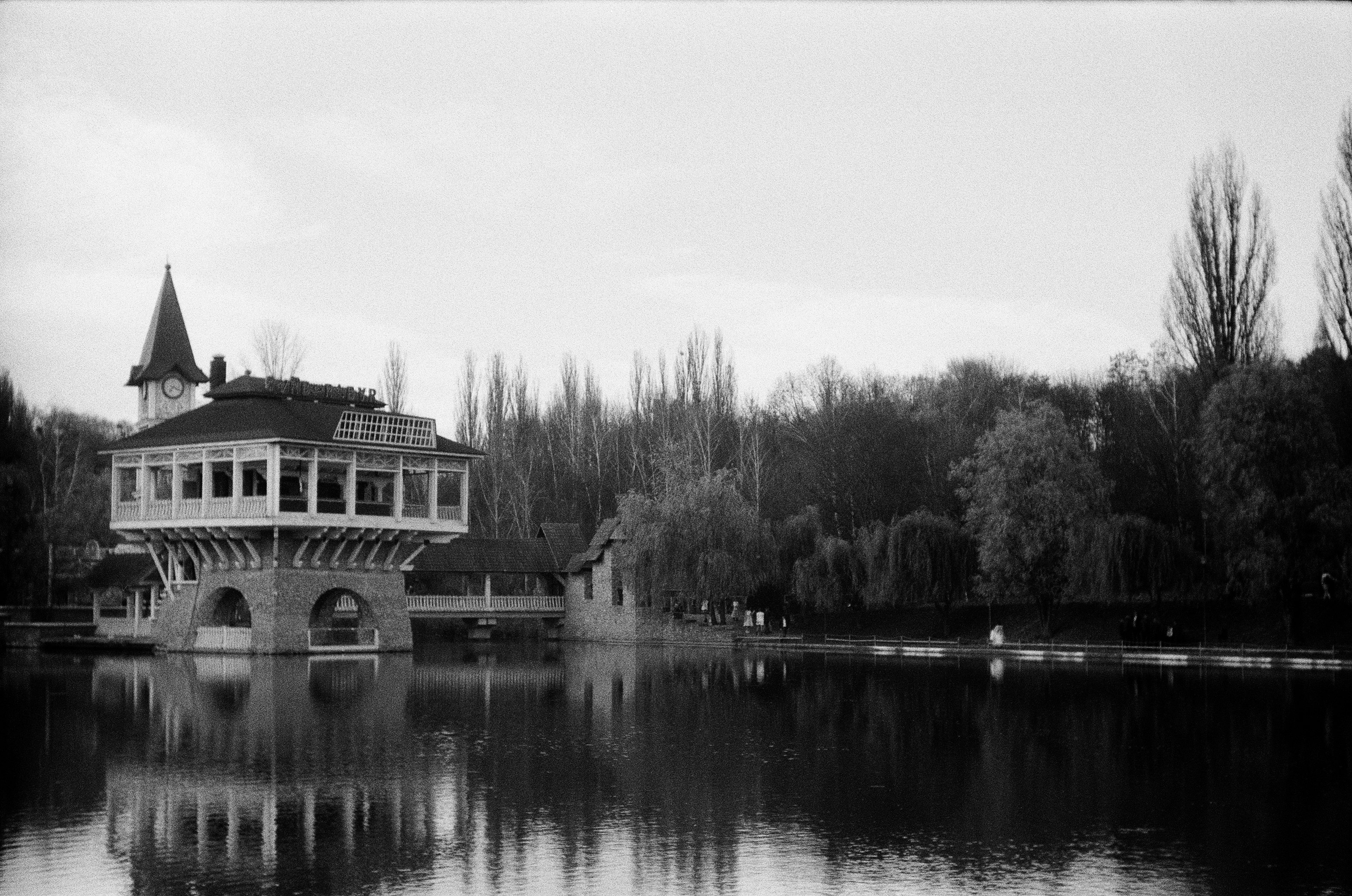 grayscale photo of house near body of water